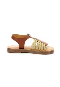 Sandal de cuero marrón con un diseño de tiras doradas, punta abierta, suela plana y correa en el tobillo con hebilla para ajuste.