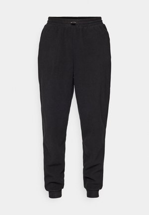 Pantalones de chándal negros hechos de una tela suave, con un corte relajado, cintura elástica con cordón ajustable y tobillos acampanados.