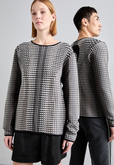 Jersey estampado en negro y gris, con un diseño texturizado de ondas. Mangas largas y escote redondo con un detalle trasero en negro sólido.
