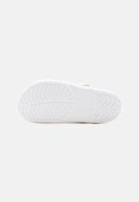 Λευκή σόλα παπουτσιού με υφή στο πέλμα και ανάγλυφες σημάνσεις μεγέθους και λογότυπου ορατές από τον κάτω μέρος.