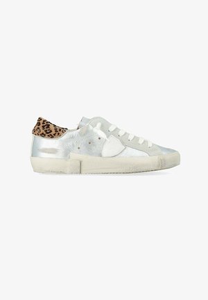 Baskets basses avec corps métallique argenté, lacets blancs, semelle beige et languette talon imprimé léopard, vues de profil sur fond blanc.
