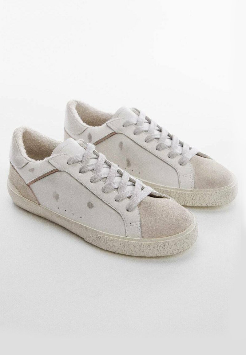 Weiße Sneaker mit einem Obermaterial aus glattem Leder und weichen Wildleder-Akzenten, runder Zehenform, Schnürdesign und subtilen Farbspritzern für Details.