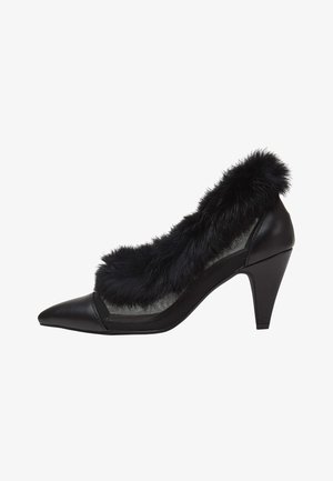 Chaussure à talon noir avec un bout pointu, un bord en fausse fourrure texturée et des côtés en mesh avec une base en cuir solide.