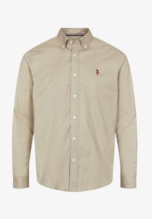 Smėlio spalvos ilgomis rankovėmis marškiniai su sagomis ant apykaklės, priekinėmis sagomis ir mažu išsiuvinėtu piešiniu kairėje krūtinės pusėje. Lygus, lengvas audinys.