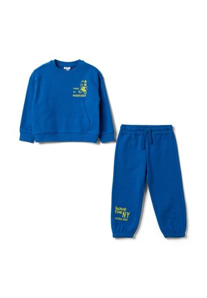 Sweat-shirt bleu vif pour enfants et pantalon assorti avec texte jaune et dessin de bande dessinée à l'avant du sweat-shirt et sur la jambe du pantalon.