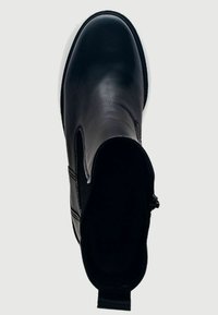 Černá kožená kotníková bota s elastickými bočními panely, zaoblenou špičkou a poutkem na patě. Hladká textura a minimální designové detaily.
