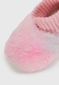 Chausson en peluche rose doux avec un poignet en maille côtelée, conçu pour la chaleur et le confort.