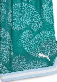 Teal gaasstof met lichtblauwe paisleypatronen en een wit Puma-logo boven een blauw-witte gestreepte zoom.
