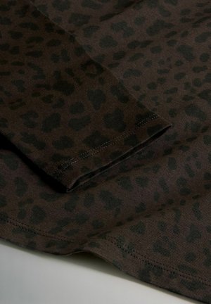 Hnedá látka s tmavým vzorom leopardie, s prešitými detailami na okrajoch a hladkým povrchom. Detailný záber na materiál.