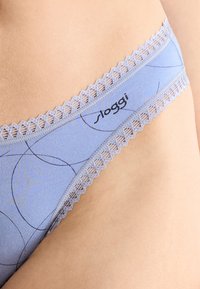 Lichtblauwe ondergoed met een geometrisch patroon, kanten rand en een Sloggi-logo. Zachte stof met een gladde textuur en delicate accenten.