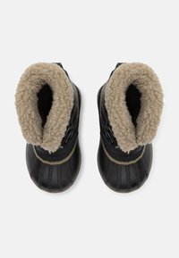 Svarte vinterstøvler med gummiutsiden, teksturert såle og en fuzzy beige fôr rundt åpningen. Har snøre detaljer for justerbarhet.