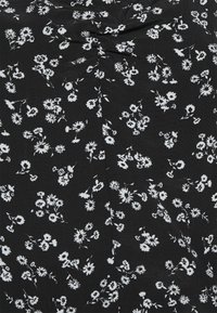 Tessuto nero con stampa floreale bianca, caratterizzato da piccoli fiori e foglie. Il materiale appare liscio con una consistenza morbida.