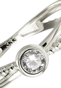 Anneau en argent avec une pierre claire ronde au centre, encadrée par des bandes texturées, finition lisse et polie avec un détail gravé.