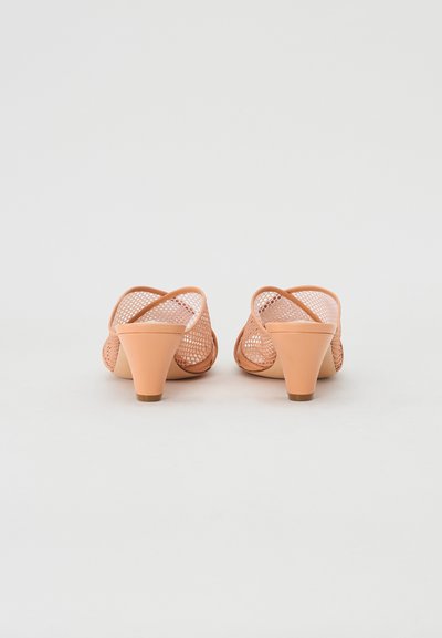 Perzikkleurige sleehakken met een bovenwerk van gaas, voorzien van een kegelvormige hak en een open achterkant. Gelaagde oppervlakte en minimalistische stijl.