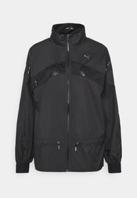 Schwarze Windbreaker-Jacke mit hohem Kragen, mit Reißverschluss vorn und strukturierten schwarzen Akzenten. Verfügt über elastische Bündchen und einen Kordelzug am Saum.
