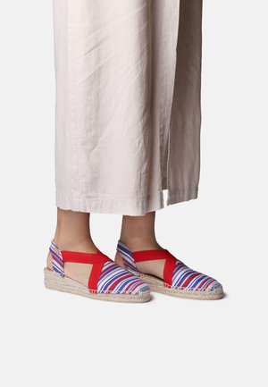 Espadrillas a righe con accenti rossi, con suola intrecciata in juta, parte posteriore aperta e design con cinturini incrociati.
