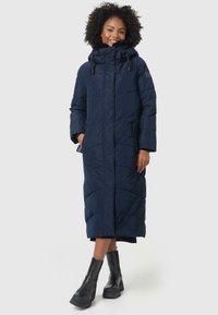 Long navy puffer coat with a high collar and adjustable drawstring hood. Features quilted design, side pockets, and a straight fit.