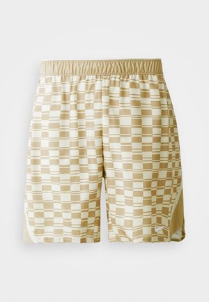 Beige athletic shorts featuring a square pattern in cream and light brown, with an elastic waistband and side vents for mobility.