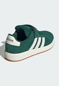 Zelena nubuk tenisica s bijelim detaljima, s dizajnom od tri pruge, podstavljenim ovratnikom i gumenenim potplatom. adidas logo na peti.