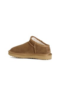Bruine suède slipper met een voering van schapenvacht, een laag profiel, een ronde neus en een getextureerde rubberen zool. Bevat gestikte accenten en een logo-detail.