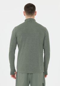 Langarm, geknoopte overhemd in olijfgroen, gemaakt van lichte, gestructureerde stof. Beschikt over duimgaten bij de manchetten en een minimum aan logodetails.