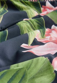Bloemstof met grote roze bloemen en groene bladeren op een donkere achtergrond. Gladde textuur, levendige kleuren en gedetailleerde bladerenpatronen.