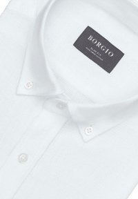 Slim-fit biała bawełniana koszula z teksturowanym materiałem i ciemną metką z napisem "BORGIO", zawierającą informacje o pielęgnacji oraz zapięcia na guziki.