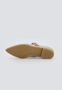 Zapato beige con puntera afilada y tacón estrecho. Parte superior de cuero suave con detalle de correa, que presenta una pequeña hebilla. Suela de goma.