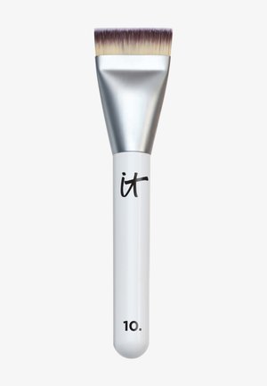 Pinceau de maquillage à tête plate avec des poils denses de couleur brun clair et blanc, virole argentée, et manche blanc portant les inscriptions "it" et "10".