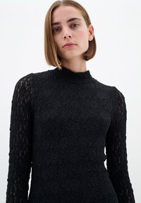 Rochie neagră din dantelă, cu mâneci lungi transparente și guler înalt; model texturat cu flori pe întreaga suprafață; siluetă ajustată.