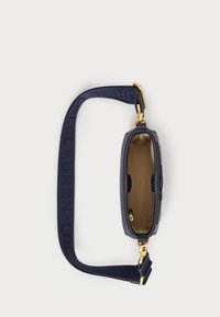 Jūras spēku ādas rokassoma ar strukturētu formu, zelta aksesuāriem un auduma siksnu ar ieliektajiem logo. Iekšpuse pārklāta ar bežīgu materiālu.