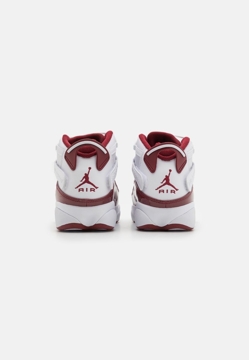 Baskets de sport rouges et blanches avec un design montante, dotées d'un collier rembourré, d'un logo au talon et d'une semelle en caoutchouc texturée.