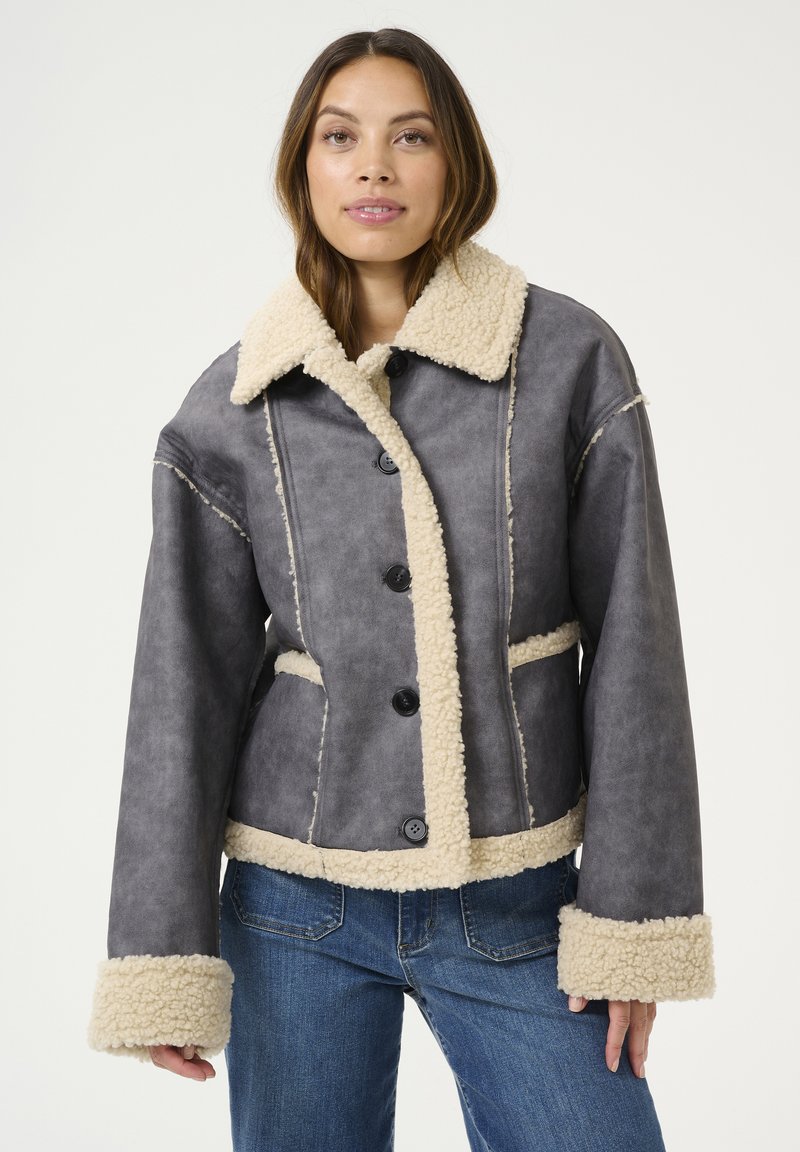 Pelēka mākslīgās ādas īsa jaka ar bēšu vilnas apkakli un piedurknēm, ar pogu aizdari un sānu kabatām.