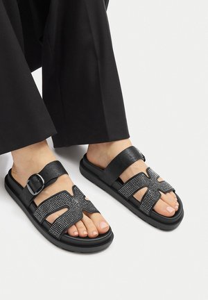 Czarne sandały z geometrycznym wzorem, ozdobione kryształkami, z regulowanym paskiem i gumową podeszwą. Gładka faktura, open-toe.