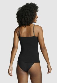 Black camisole with thin spaghetti straps, fitted design, and smooth cotton material. Back view shows a seamless hem and minimal detailing.