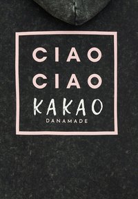 Schwarzer Hoodie mit einem pinken rechteckigen Grafik, auf der die Worte "CIAO CIAO KAKAO DANAMADE" in einer Mischung aus fetten und handgeschriebenen Stilen stehen.