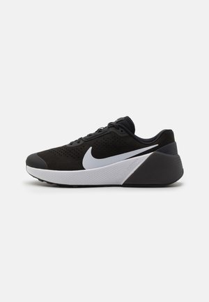 Chaussure de running Nike noire et blanche avec tige perforée, logo Swoosh blanc proéminent et semelle amortissante vue de profil.
