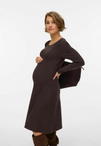 Tumši brūnas krāsas garām piedurknēm grūtnieču kleita ar apaļu kakla izgriezumu, pieguļošu korseti un izplatītu svārku, kopā ar melnu plecu somu.