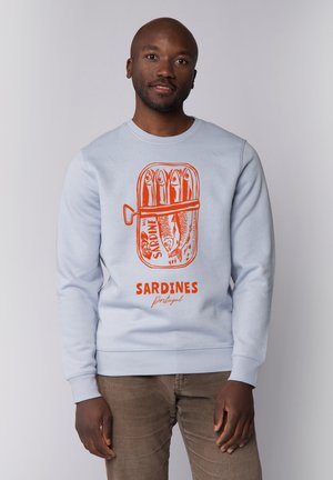 Lichtblauwe sweatshirt met een oranje sardineblikje-graphic met de tekst "SARDINES" en "Portugal", geribbelde manchetten en een relaxte pasvorm.