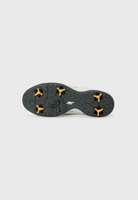 Semelle de chaussure de sport blanche avec une surface texturée grise et des crampons de traction jaunes. Présente un logo et un design flexible pour une meilleure adhérence.