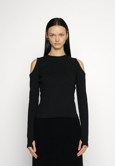 Schwarzes Langarmoberteil mit Cold-Shoulder-Ausschnitten, gerippter Textur, taillierter Passform und Rundhalsausschnitt, kombiniert mit einem gerippten schwarzen Rock.