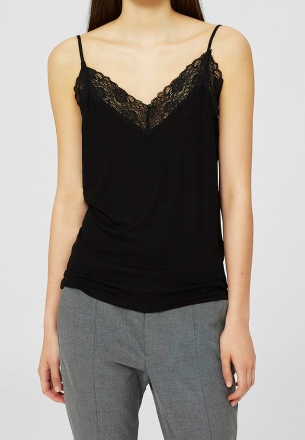 Camisole nera con bordo in pizzo al colletto, dotata di sottili spalline regolabili e vestibilità morbida. Abbinata a pantaloni grigi su misura.