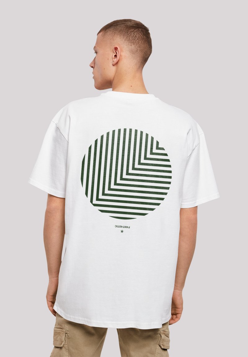 White cotton t-shirt featuring a large green circle design with alternating diagonal stripes. Relaxed fit with short sleeves and crew neck.