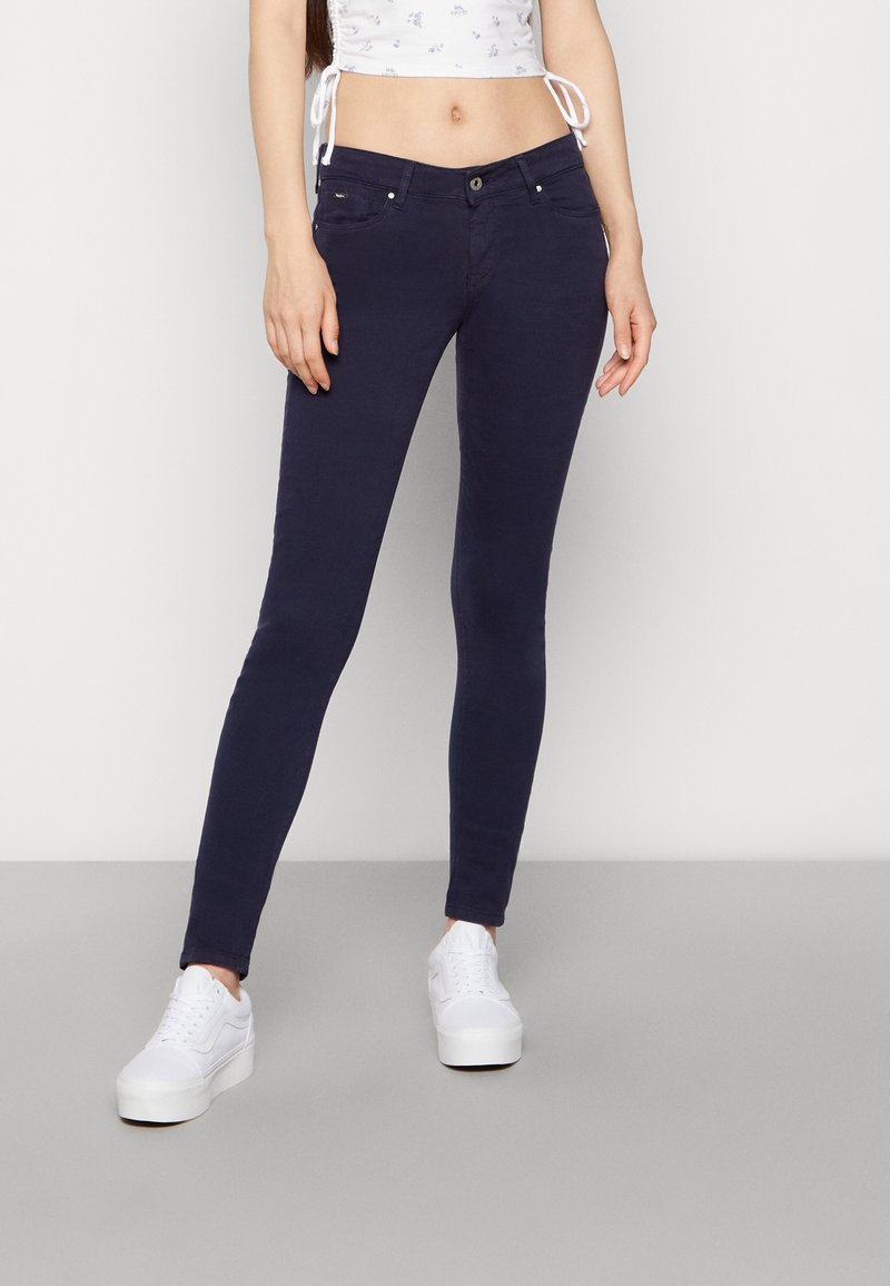 Jeans skinny azul marino fabricados con tejido elástico, que cuentan con cinco bolsillos, cierre frontal con botón y cremallera, y una textura suave.