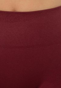 Bordeaux ribbelde tailleband van leggings, gemaakt van zacht, rekbaar materiaal met een gladde textuur en gelijkmatige kleur, ontworpen voor comfort en pasvorm.