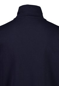 Pullover blu navy con colletto alto, realizzato in morbido cotone. Presenta un colore solido e una texture liscia, senza loghi o motivi visibili.