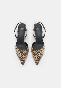 Pair of pointed-toe slingback shoes with leopard print pattern and black insoles labeled "Bata Real Leather" on a white background.