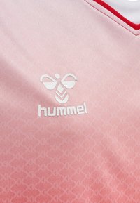 Rosa Trikot mit einem Verlaufdesign, versehen mit einem weißen "hummel"-Logo und rundem Ausschnitt. Glatte Textur mit dezenten geometrischen Mustern.