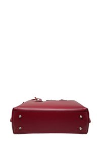 Czerwona, strukturalna torebka z gładkiej skóry, z płaskim dnem z metalowymi nóżkami oraz górnymi uchwytami. Minimalistyczny design bez widocznych elementów metalowych.