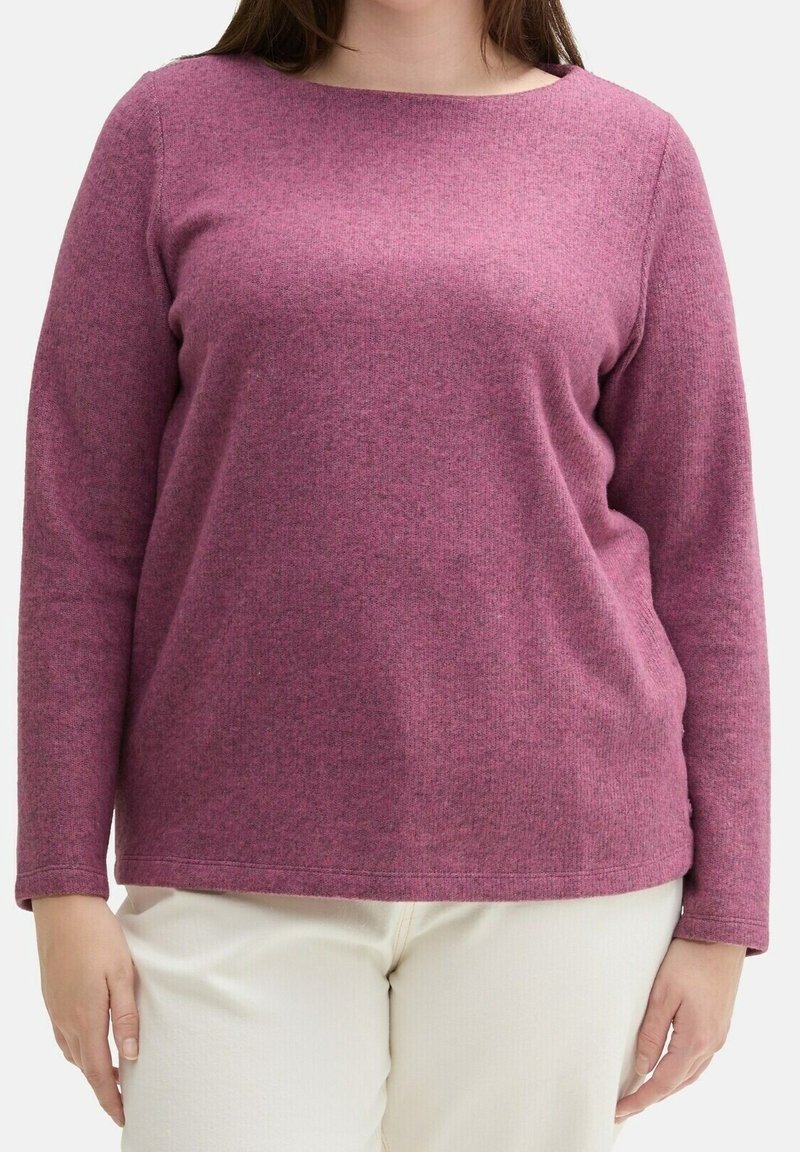 Pull-over à manches longues en tissu tricoté rose chiné, avec un col large et une coupe décontractée, associé à un pantalon texturé de couleur claire.